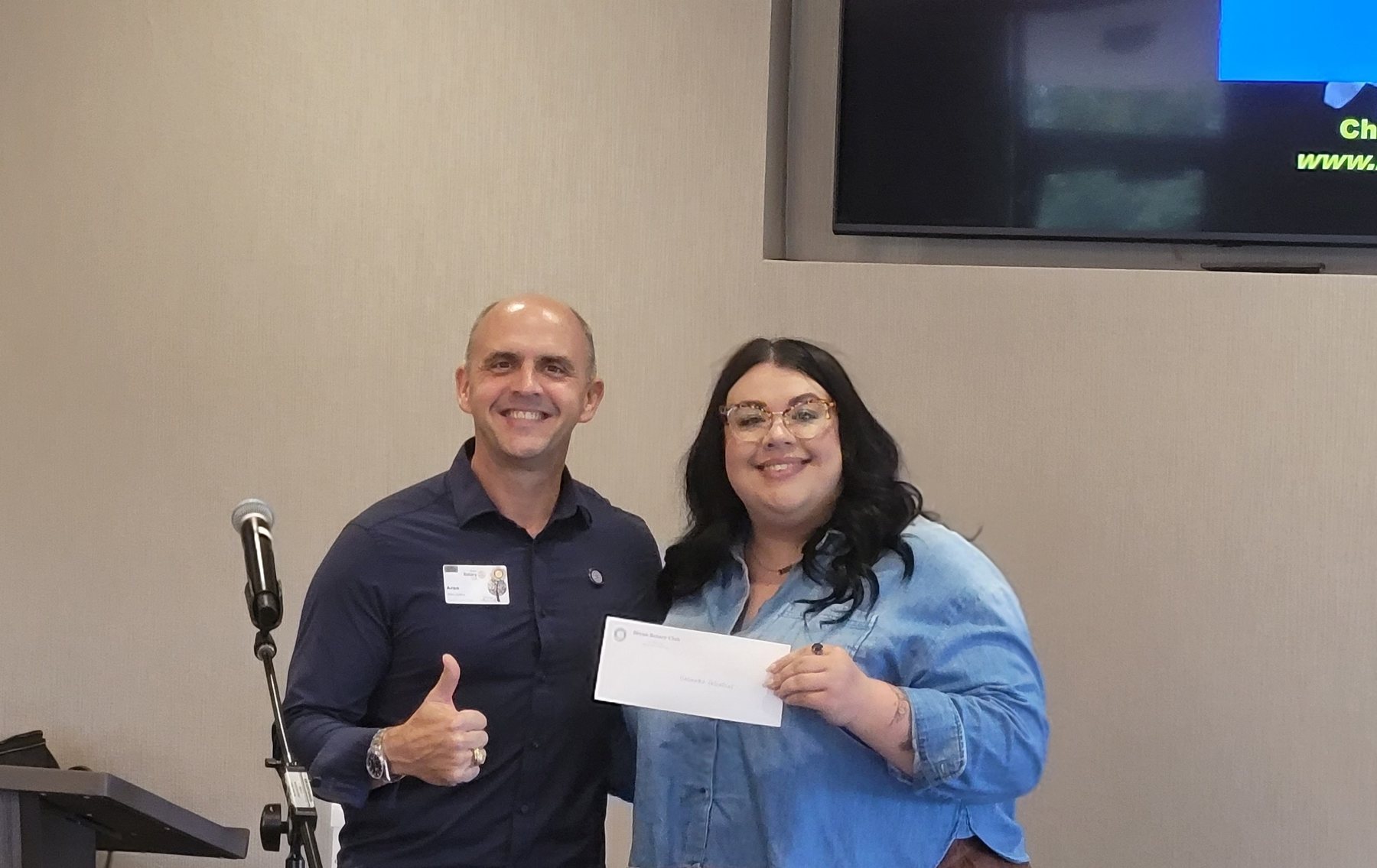 A community supporter presenting a donation to Unlimited Potential