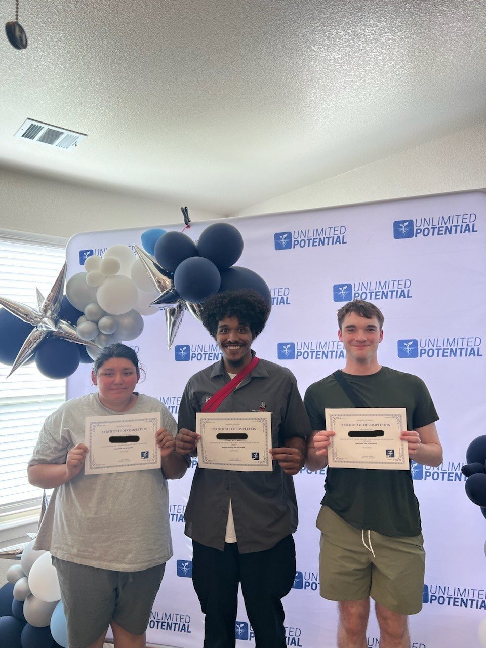 Young adults holding certificates at a celebration